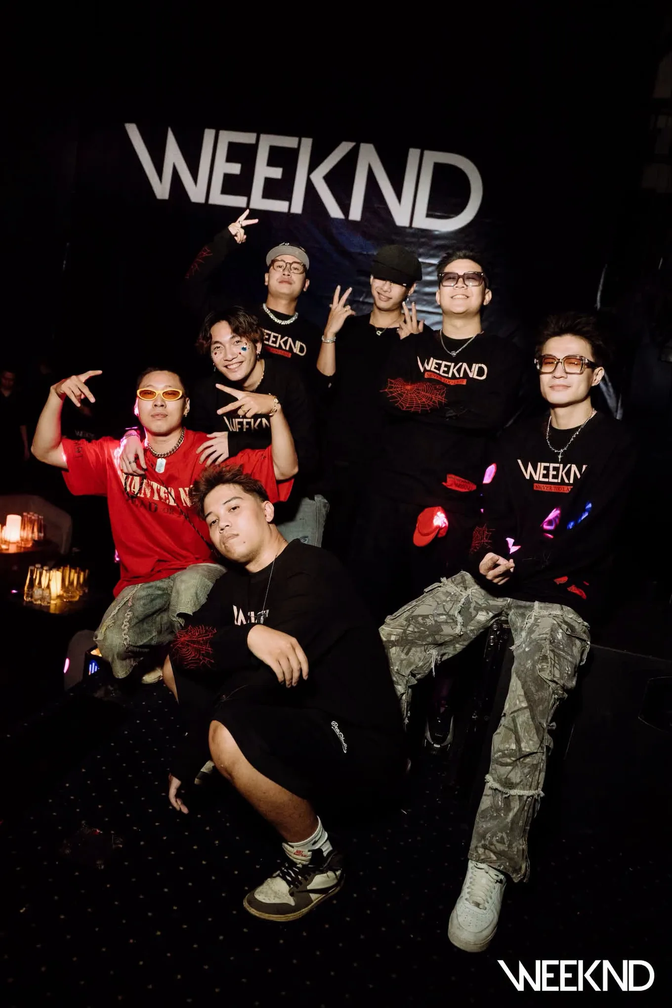 Nhóm khách chụp ảnh trước phông nền wordmark WEEKND