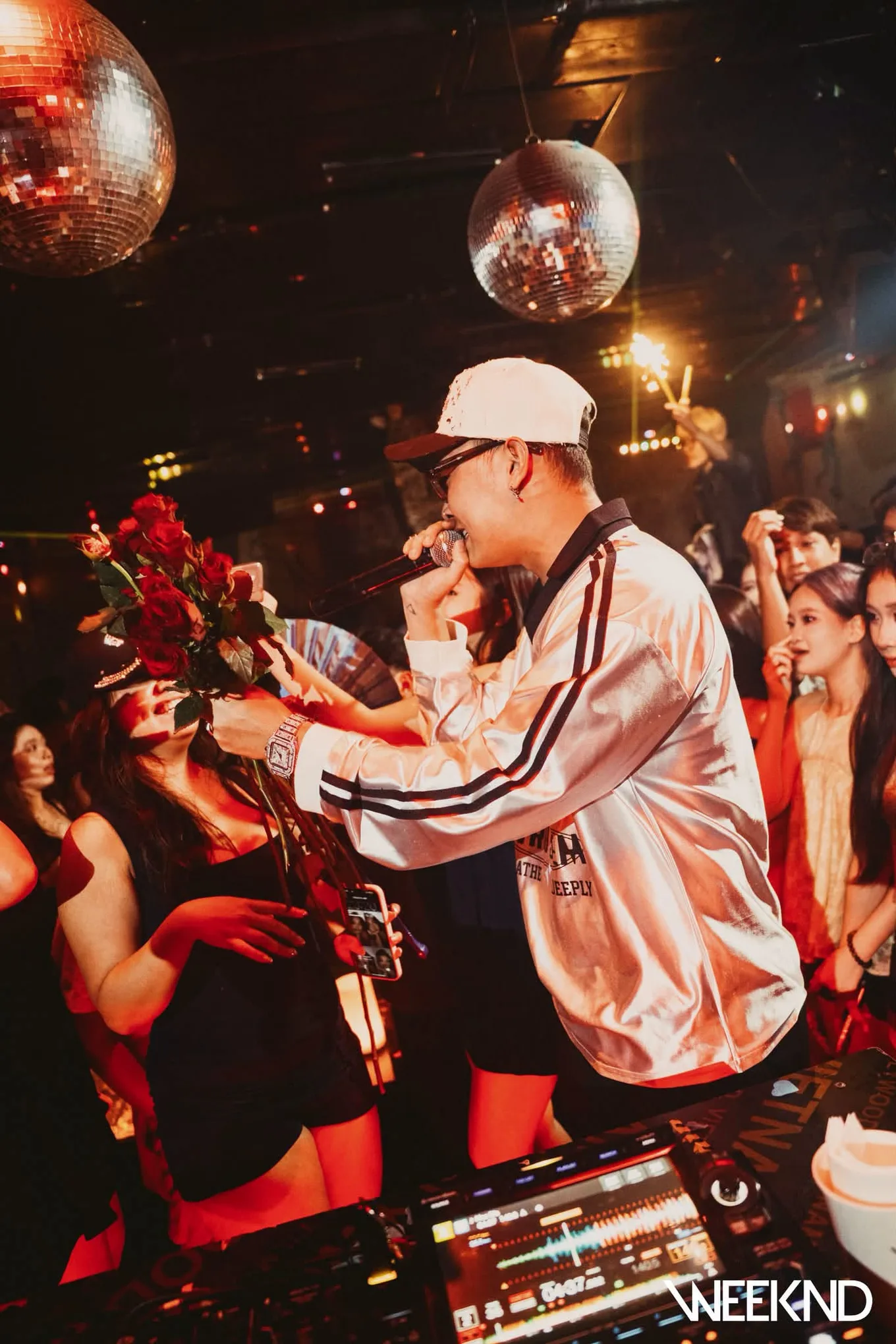 Nghệ sĩ cầm mic biểu diễn ngay giữa sàn, dưới dàn quả cầu disco